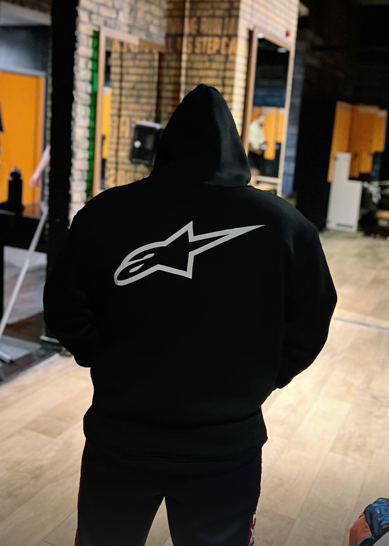 Alpinestar reflektörlü siyah hoodie giyen kişi, arkadan görünüm