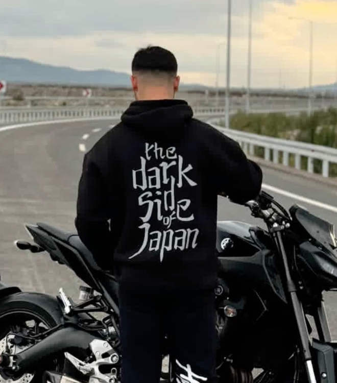 Motosikletin yanında Dark Side of Japan reflektörlü siyah hoodie giyen sürücü, arkadan görünüm