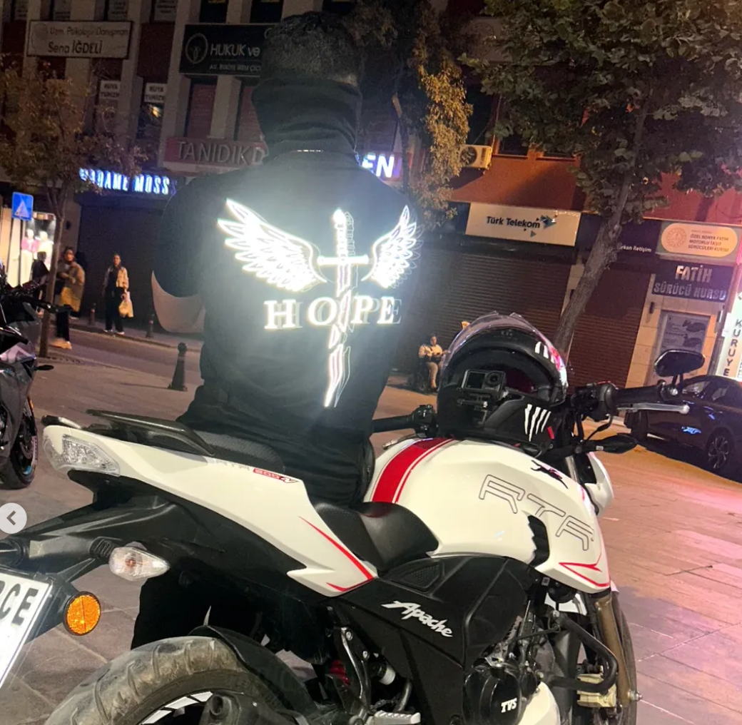 Gece şehirde motosiklet üzerinde parlayan Hope reflektör baskılı tişört
