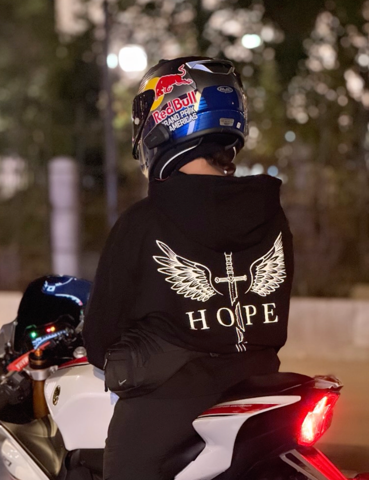 Hope reflektörlü motorcu hoodie giyen sürücü motosikletin üzerinde