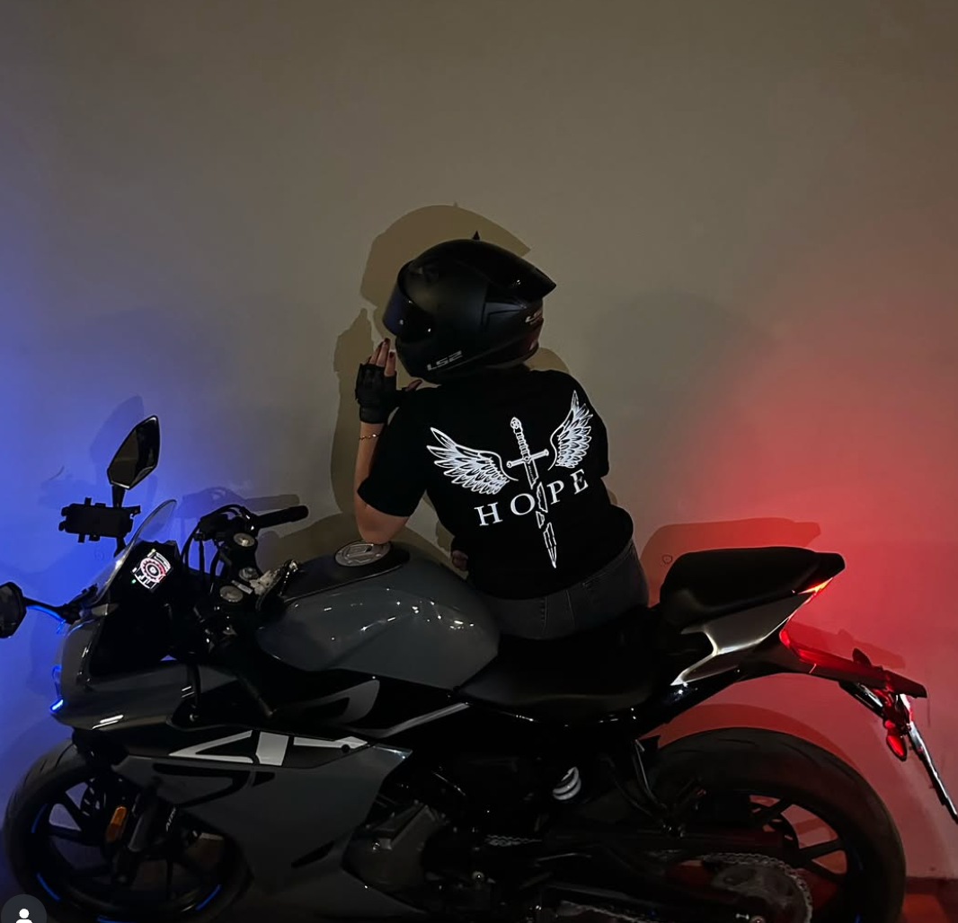 Motosiklet üzerinde Hope reflektör baskılı siyah tişört giyen sürücü