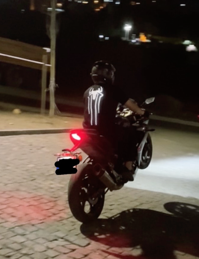 Gece motosiklet üzerinde parlayan Spider reflektör baskılı siyah tişört